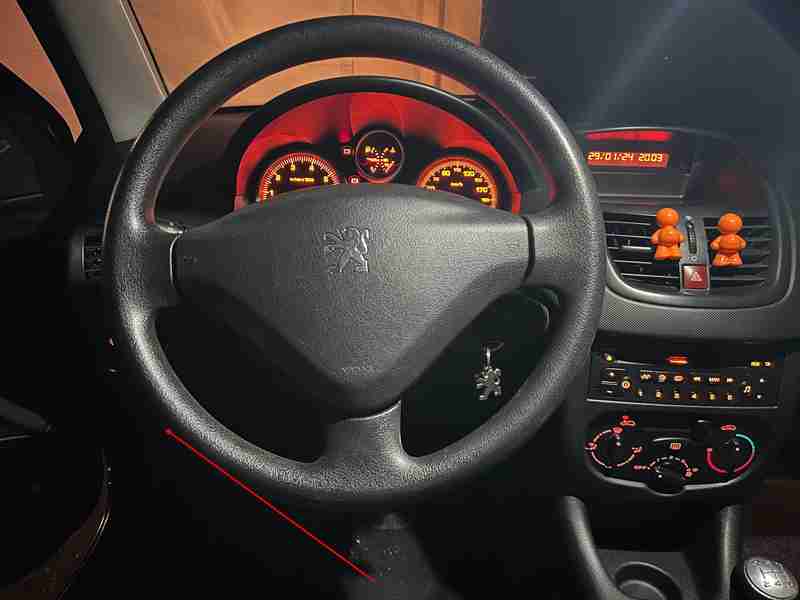 Intérieur de nuit d une Peugeot 206 plus avec le tableau de bord orange éclairé