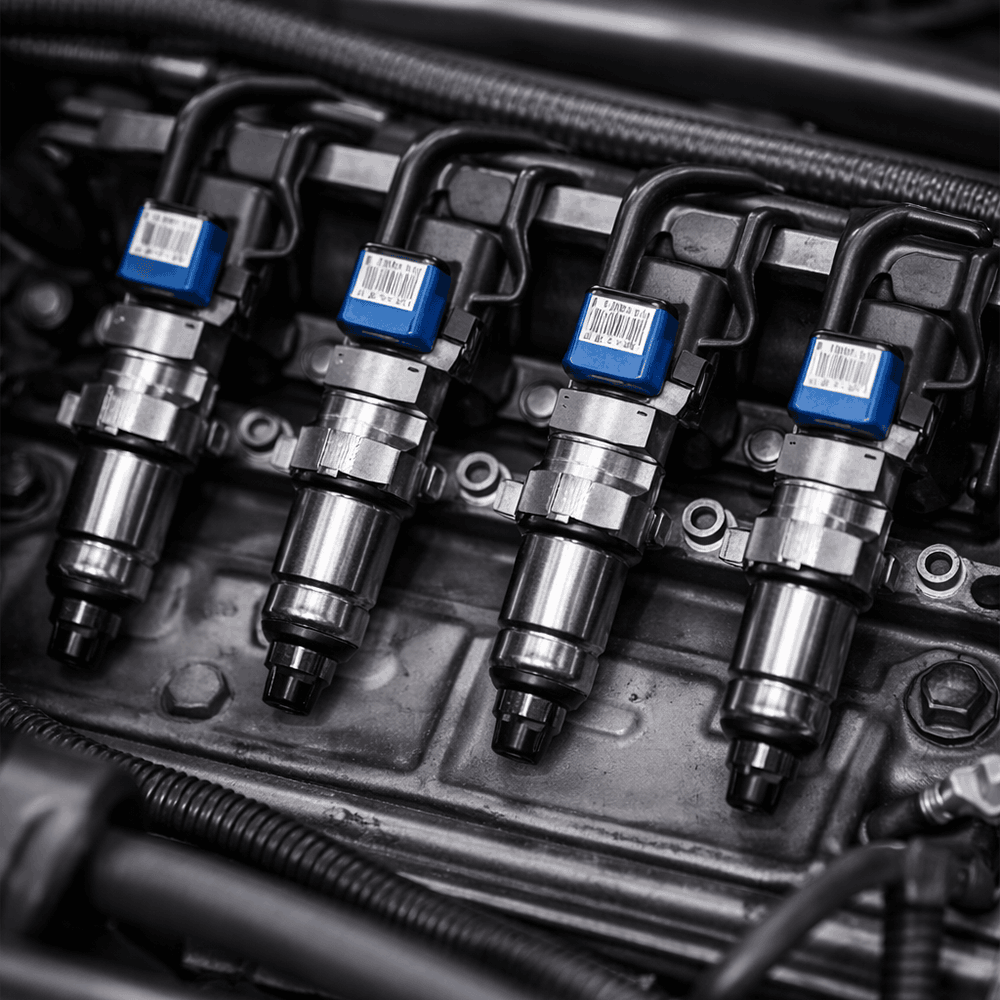 Quatre injecteurs de moteur de voiture avec codes barres et connecteurs bleus
