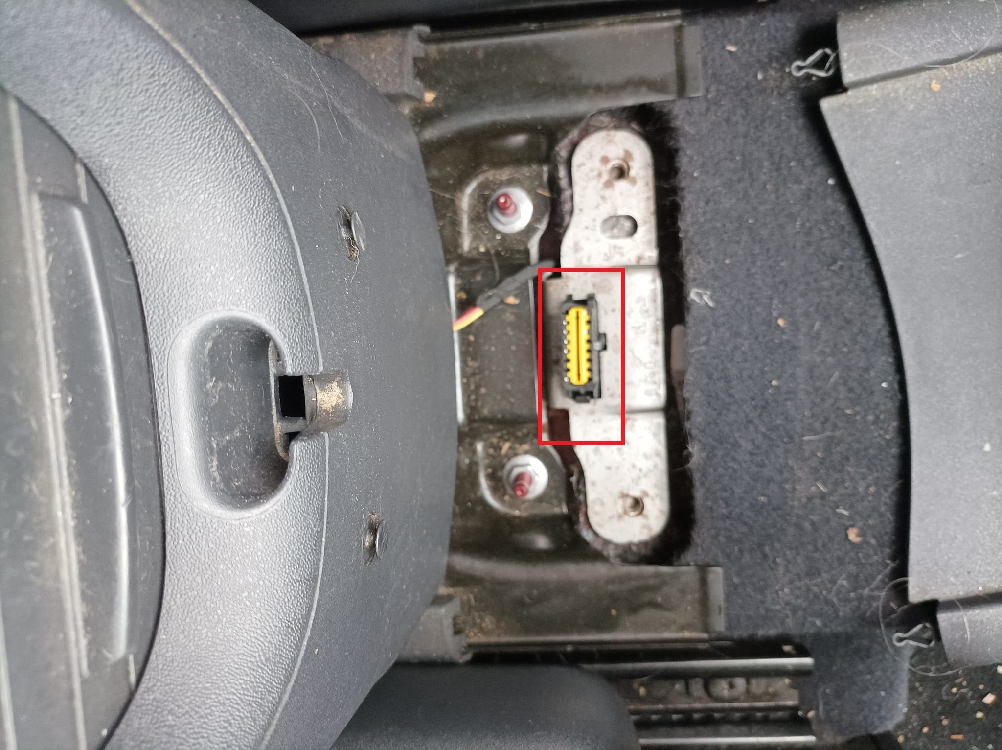 Prise de diagnostic OBD jaune accessible dans la console centrale d'un véhicule