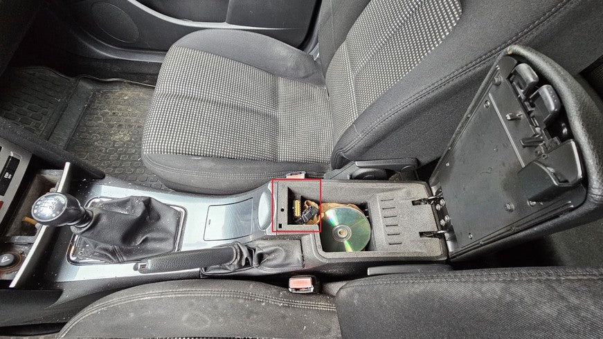Emplacement de la prise OBD2 de diagnostic sous l accoudoir d une Peugeot 407