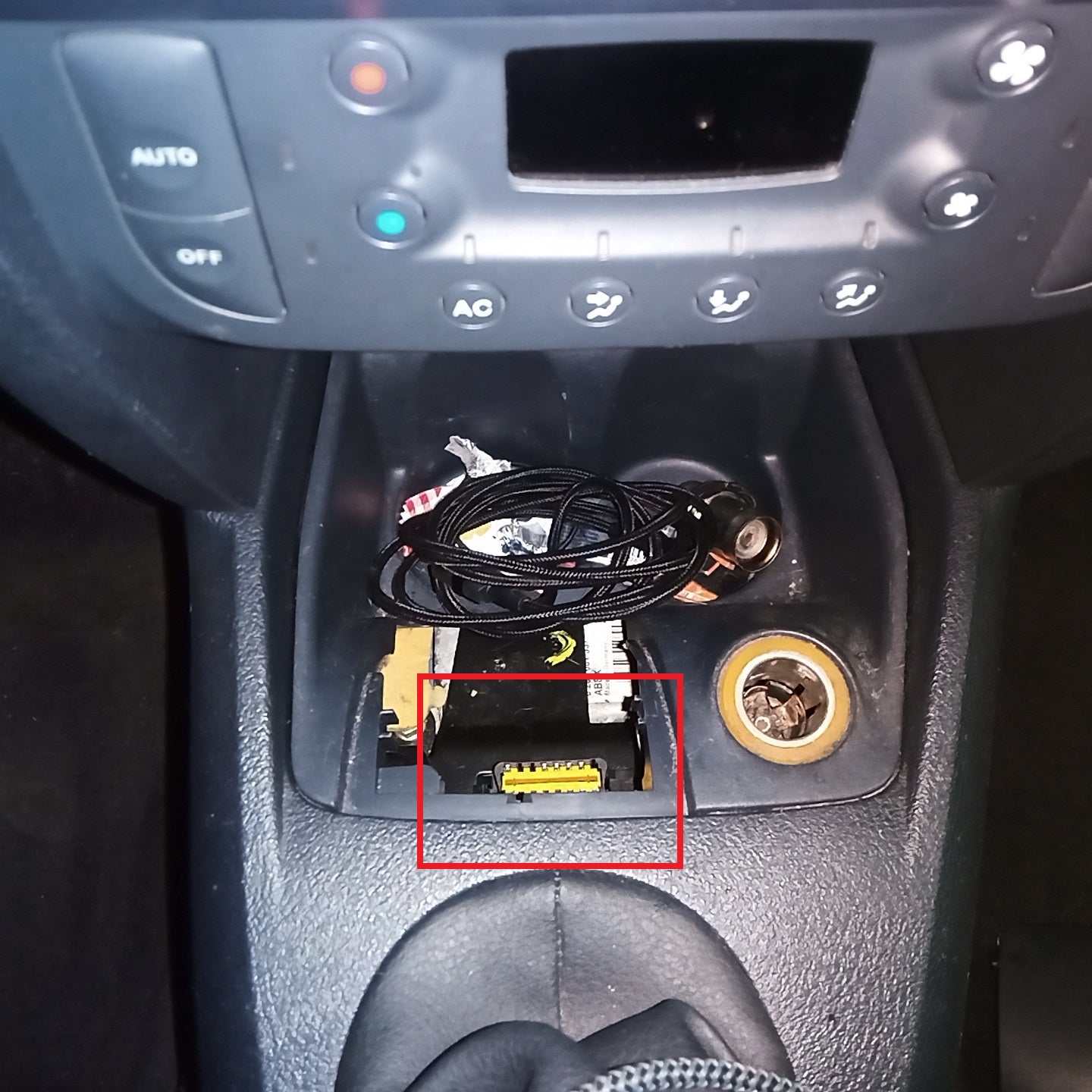Localisation de la prise de diagnostic OBD2 sous la console centrale d'une voiture