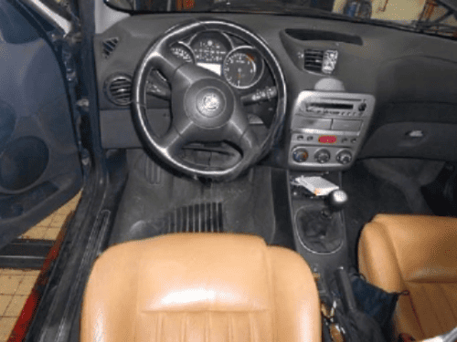 Tableau de bord et volant en cuir noir d une Alfa Romeo 147 avec sellerie en cuir fauve