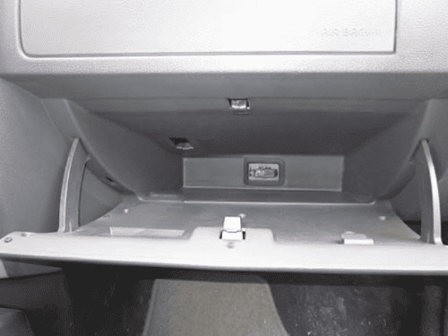 Vide-poche passager ouvert d une Dacia Logan pour acceder a la prise de diagnostic