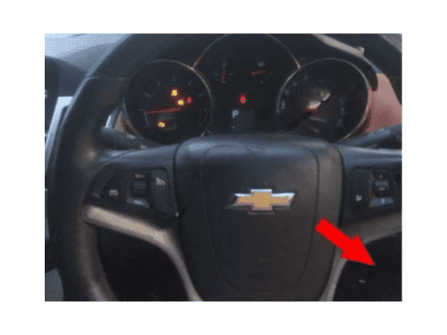 Volant d une Chevrolet Cruze conduite a droite avec voyants allumes au tableau de bord