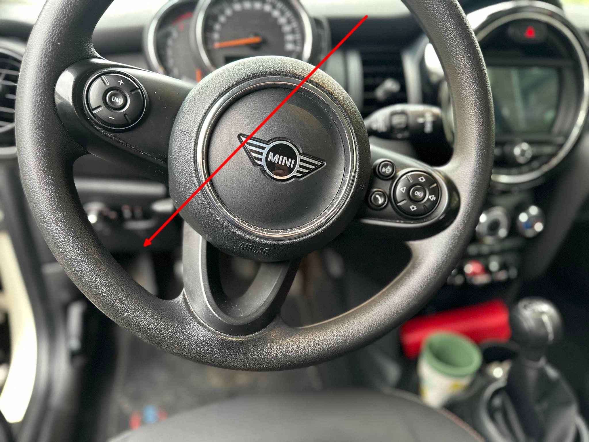 Flèche rouge pointant vers les boutons du volant d une Mini Cooper lors d un diagnostic auto