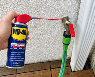 WD-40 Multifonction pulvérisé sur un robinet extérieur avec le tube relevé