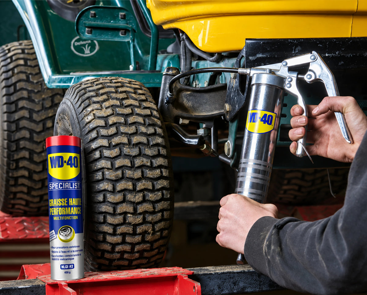 Graissage d’un tracteur tondeuse au pistolet à graisse, à côté de la cartouche WD-40 Specialist Graisse haute performance 400 g